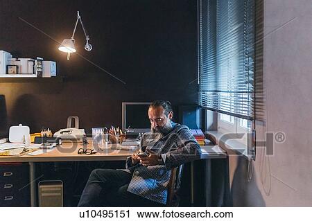 Man using cellphone at desk View Large Photo Image Stock Image - Man using cellphone at desk. Fotosearch