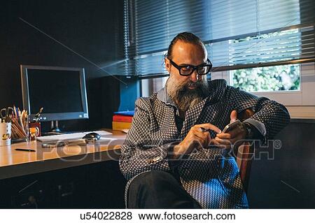 Man using cellphone at desk View Large Photo Image Stock Photo - Man using cellphone at desk. Fotosearch