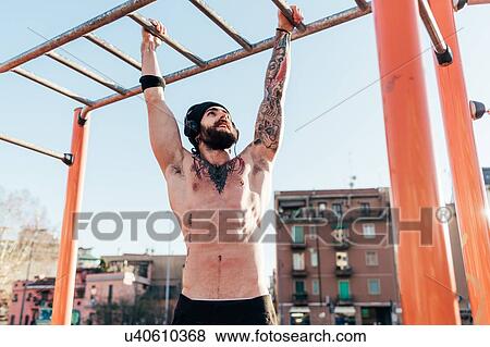 Man using horizontal ladder in outdoor gym View Large Photo Image Stock Photo - Man using horizontal ladder in outdoor gym. Fotosearch