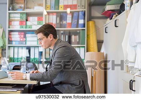 Man using laptop in office View Large Photo Image Stock Image - Man using laptop in office. Fotosearch