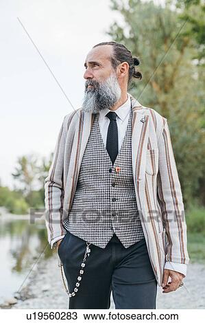 Stock Image - Man walking by lake. Fotosearch