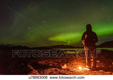 Stock Photo - Man watching aurora borealis, Narsaq, Vestgronland, Greenland. Fotosearch