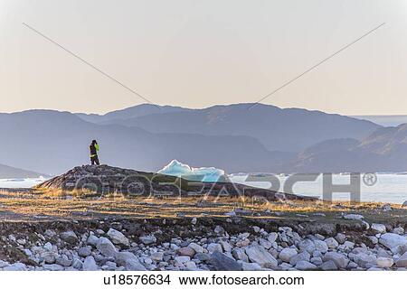 Picture - Man watching iceberg, Narsaq, Vestgronland, Greenland. Fotosearch