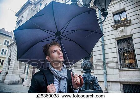 Man with umbrella on morning commute, Budapest, Hungary View Large Photo Image Stock Photo - Man with umbrella on morning commute, Budapest, Hungary. Fotosearch