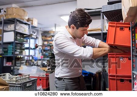 Man working on charts and plans in warehouse View Large Photo Image Stock Image - Man working on charts and plans in warehouse. Fotosearch