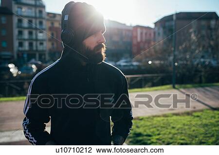 Stock Image - Man wrapped up warmly in park. Fotosearch