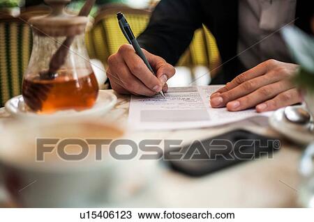 Man writing while having morning coffee View Large Photo Image Stock Image - Man writing while having morning coffee. Fotosearch
