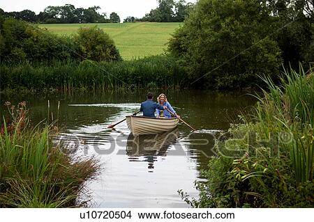 Picture - Mature couple in rowing boat on rural lake. Fotosearch