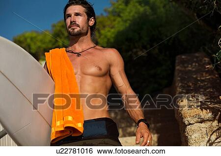 Mid adult male surfer carrying surfboard on beach, Camps Bay Beach, Cape Town, South Africa View Large Photo Image Stock Photograph - Mid adult male surfer carrying surfboard on beach, Camps Bay Beach, Cape Town, South Africa. Fotosearch