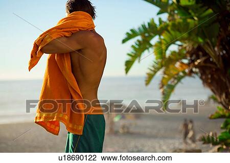 Mid adult male surfer drying off on beach, Camps Bay Beach, Cape Town, South Africa View Large Photo Image Stock Image - Mid adult male surfer drying off on beach, Camps Bay Beach, Cape Town, South Africa. Fotosearch