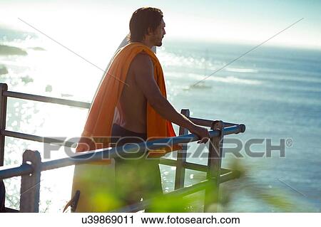 Mid adult male surfer looking out at sea from balcony, Cape Town, Camps Bay Beach, Cape Town, South Africa View Large Photo Image Stock Image - Mid adult male surfer looking out at sea from balcony, Cape Town, Camps Bay Beach, Cape Town, South Africa. Fotosearch