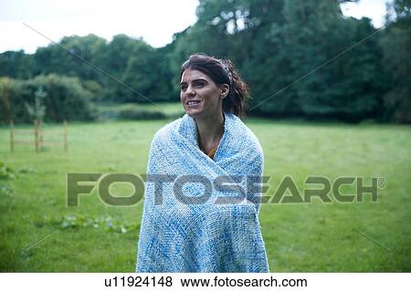 Mid adult woman standing in rural field wrapped in blanket, portrait View Large Photo Image Stock Photo - Mid adult woman standing in rural field wrapped in blanket, portrait. Fotosearch