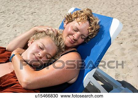 Mother and daughter relaxing on beach View Large Photo Image Stock Image - Mother and daughter relaxing on beach. Fotosearch