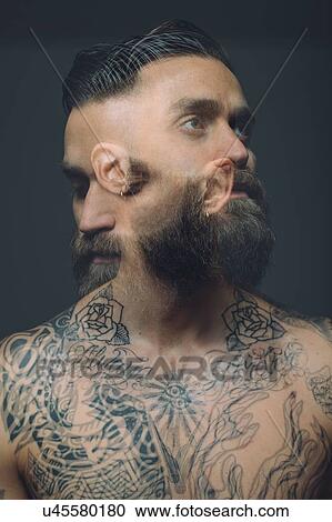Stock Image - Multiple exposure of bare chested young man, covered in tattoos, worried, pensive expression. Fotosearch