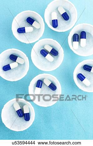 Paper medicine pots with blue and white capsules. View Large Photo Image Picture - Paper medicine pots with blue and white capsules.. Fotosearch