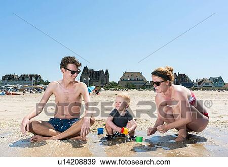 Parents playing with toddler on beach View Large Photo Image Stock Photo - Parents playing with toddler on beach. Fotosearch