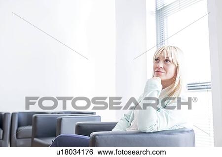 Pensive mid adult woman sitting in doctor's waiting room with hand on chin. View Large Photo Image Stock Photograph - Pensive mid adult woman sitting in doctor's waiting room with hand on chin.. Fotosearch