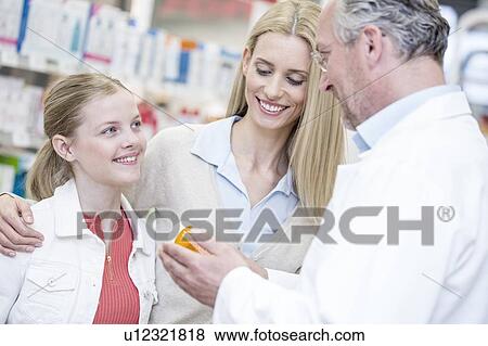 Pharmacist giving medicine to woman and girl in pharmacy. View Large Photo Image Stock Photo - Pharmacist giving medicine to woman and girl in pharmacy.. Fotosearch