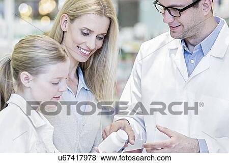 Pharmacist giving medicine to woman and girl in pharmacy. View Large Photo Image Stock Photo - Pharmacist giving medicine to woman and girl in pharmacy.. Fotosearch