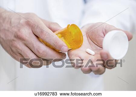 Pharmacist pouring pill into hand. View Large Photo Image Stock Image - Pharmacist pouring pill into hand.. Fotosearch