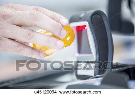 Picture - Pharmacist scanning medicine with barcode reader in pharmacy.. Fotosearch