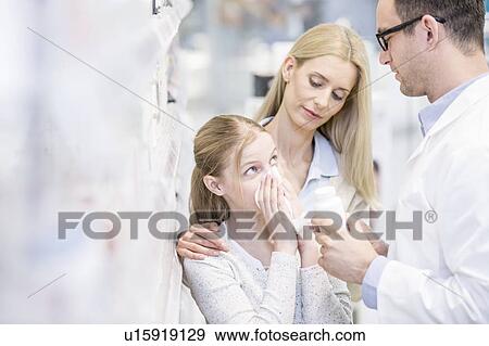 Stock Photo - Pharmacist showing medicine to sick girl and woman in pharmacy.. Fotosearch