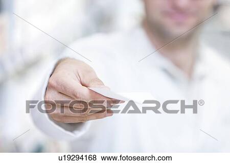 Stock Photo - Pharmacist showing prescription in pharmacy.. Fotosearch