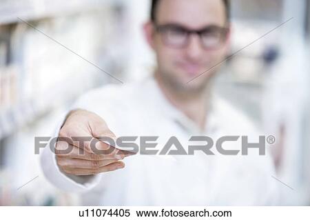 Stock Photography - Pharmacist showing prescription in pharmacy.. Fotosearch