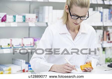 Pharmacist writing notes on a prescription. View Large Photo Image Stock Photo - Pharmacist writing notes on a prescription.. Fotosearch