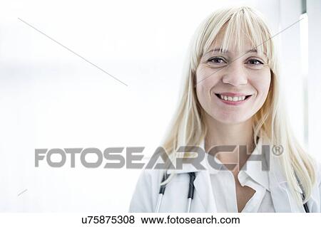 Stock Photo - Portrait of female doctor smiling towards camera.. Fotosearch