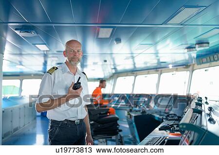 Portrait of ship's captain on bridge onboard ship in port View Large Photo Image Stock Image - Portrait of ship's captain on bridge onboard ship in port. Fotosearch