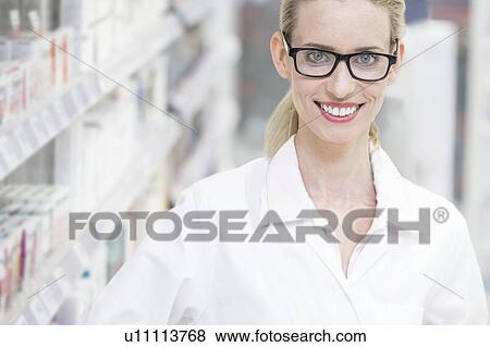 Portrait of smiling female pharmacist standing in pharmacy. View Large Photo Image Stock Photo - Portrait of smiling female pharmacist standing in pharmacy.. Fotosearch