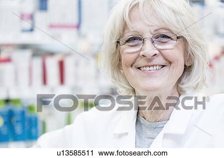 Portrait of smiling senior female pharmacist standing in pharmacy. View Large Photo Image Stock Image - Portrait of smiling senior female pharmacist standing in pharmacy.. Fotosearch
