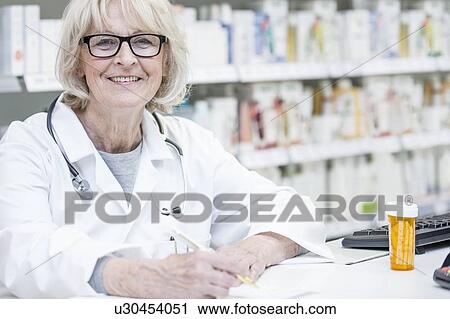 Portrait of smiling senior pharmacist writing on prescription. View Large Photo Image Stock Image - Portrait of smiling senior pharmacist writing on prescription.. Fotosearch