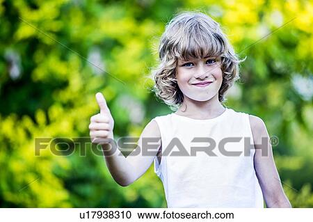 Portrait of young boy showing thumbs up, smiling. View Large Photo Image Stock Image - Portrait of young boy showing thumbs up, smiling.. Fotosearch