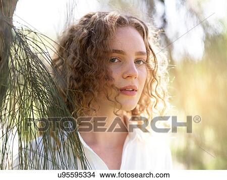 Picture - Portrait of young woman in nature. Fotosearch