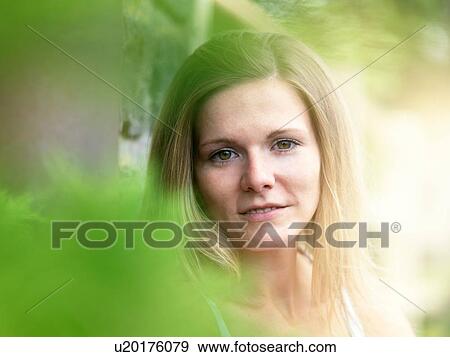 Stock Photo - Portrait of young woman in nature. Fotosearch