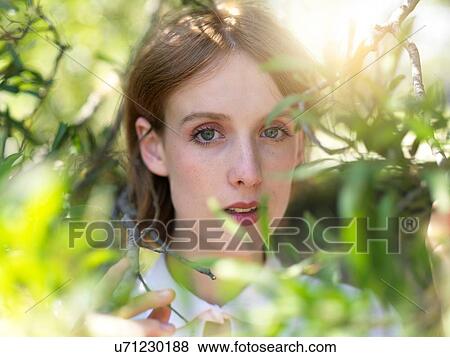 Stock Photo - Portrait of young woman in nature. Fotosearch