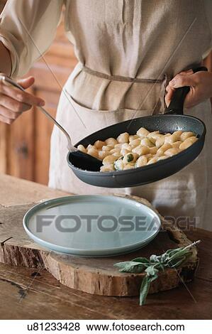 Potato gnocchi in frying pan being served View Large Photo Image Stock Photo - Potato gnocchi in frying pan being served. Fotosearch