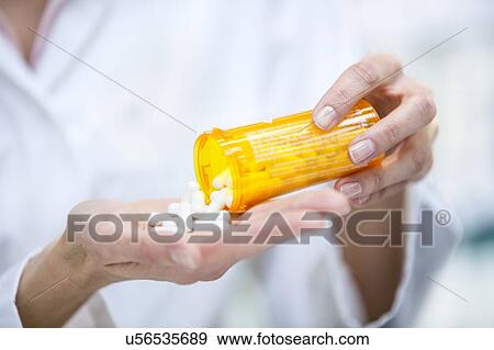 Stock Photo - Pouring pills into hand.. Fotosearch
