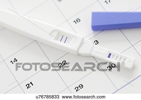 Stock Image - Pregnancy test showing positive result and calendar.. Fotosearch