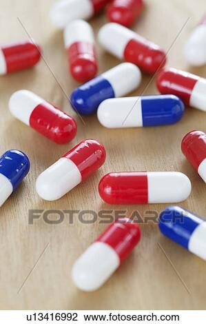 Stock Image - Red and white and blue and white drug capsules.. Fotosearch