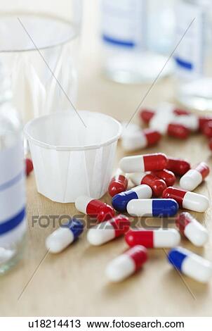 Stock Image - Red and white and blue and white drug capsules.. Fotosearch