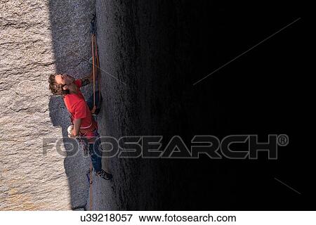 Stock Photo - Rock climber in shadow of rock. Fotosearch