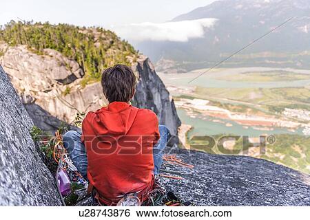 Stock Photograph - Rock climber relaxing at top of rock, Squamish, Canada. Fotosearch