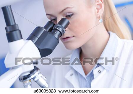 Stock Photo - Scientist using microscope.. Fotosearch