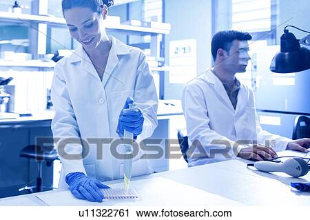 Stock Image - Scientist using pipette in the laboratory.. Fotosearch