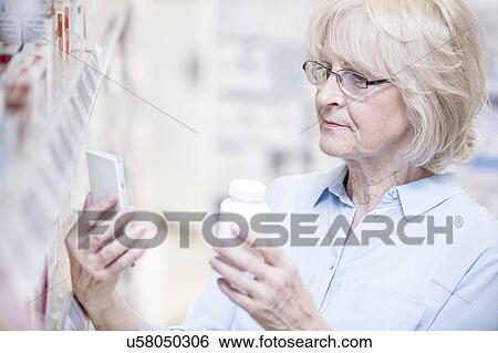 Senior woman checking medicine on mobile phone in pharmacy. View Large Photo Image Stock Photograph - Senior woman checking medicine on mobile phone in pharmacy.. Fotosearch