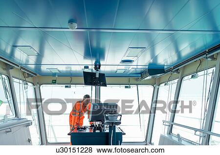 Stock Photo - Ship worker on bridge of ship. Fotosearch