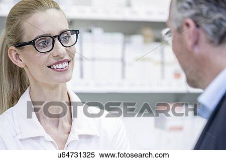 Smiling female pharmacist talking to senior male customer in pharmacy. View Large Photo Image Stock Photography - Smiling female pharmacist talking to senior male customer in pharmacy.. Fotosearch